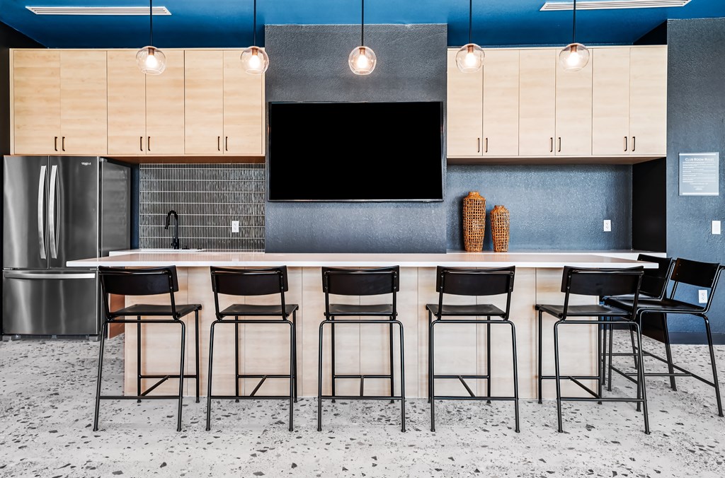 A kitchen with a bar area featuring a counter and chairs.