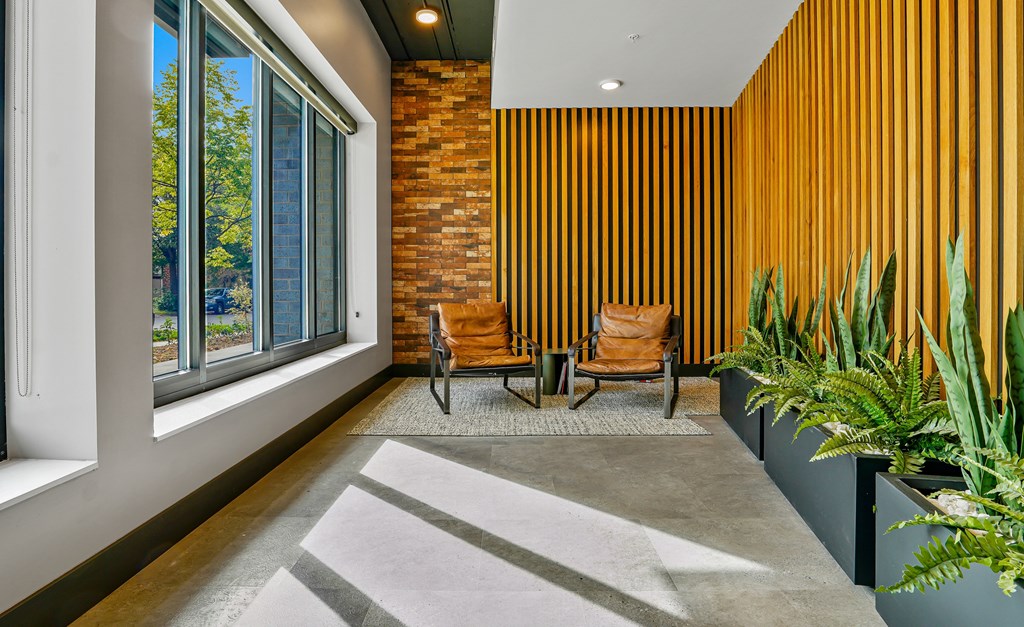 a lobby with two chairs and a table and a large window