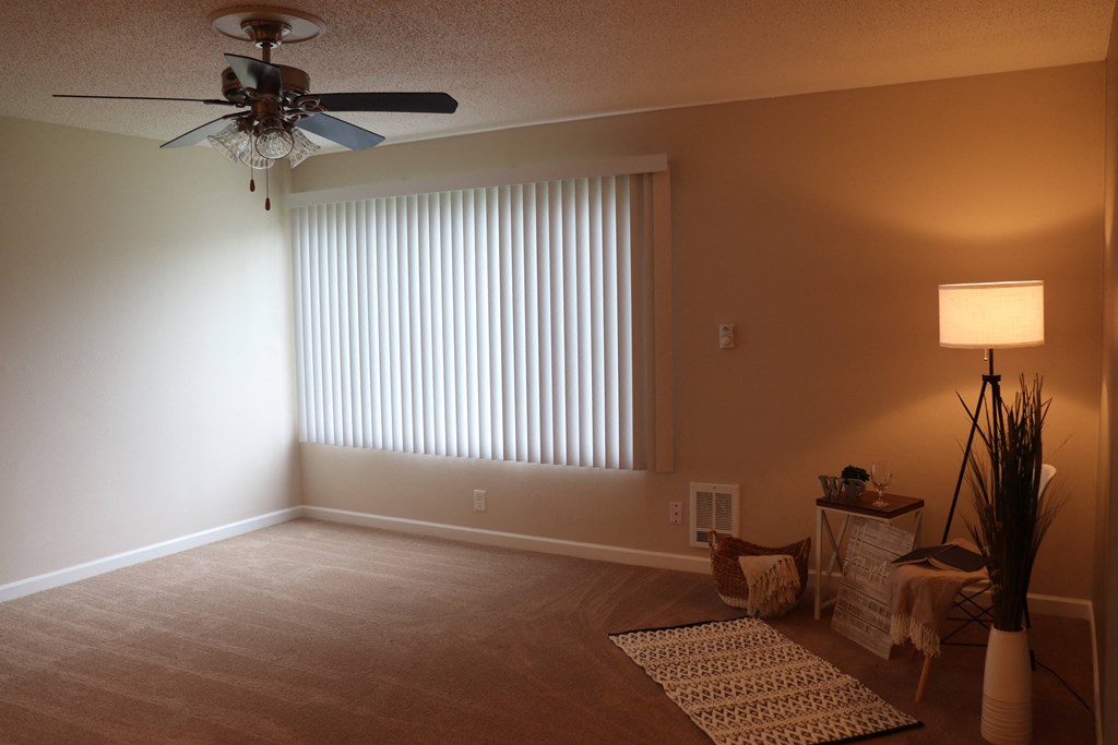 a living room with a ceiling fan and a window