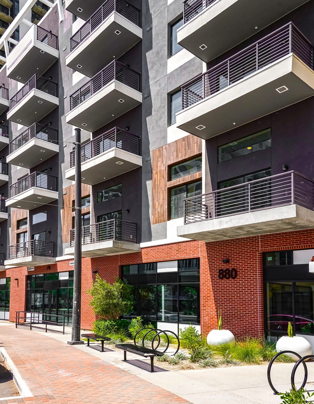 A modern building with balconies and a brick facade.