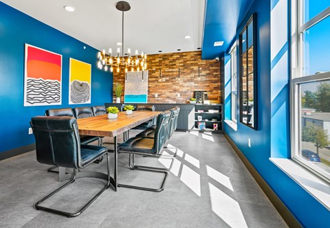 a dining room with blue walls and a wooden table and chairs