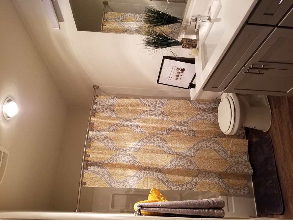 a small bathroom with a shower curtain and a toilet