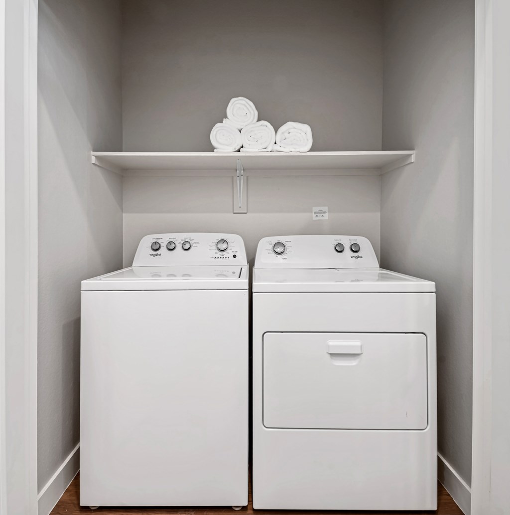 Two white washing machines in a laundry room.