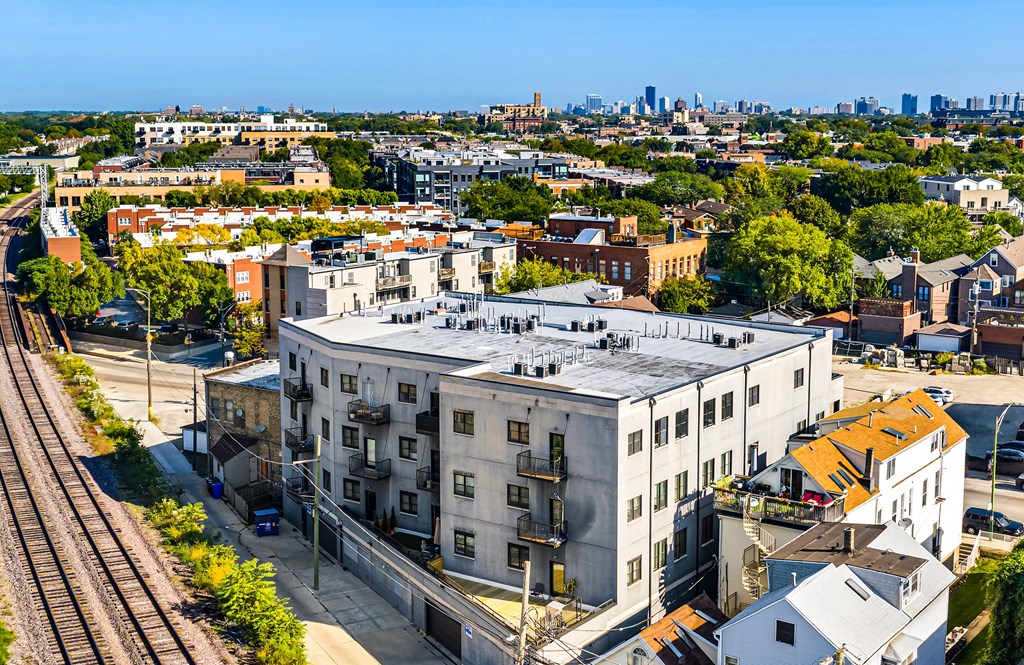 A train track runs through a city with buildings on either side.