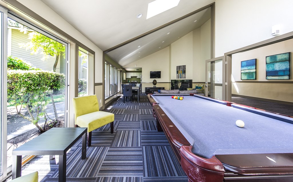a game room with a pool table and a view of the patio