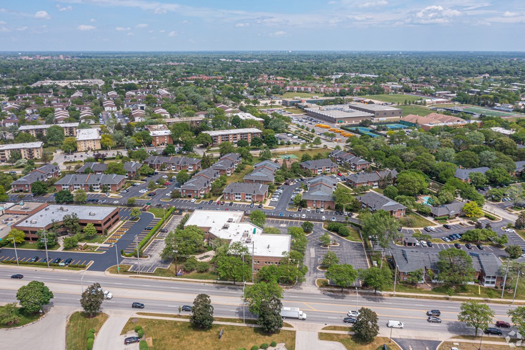 an aerial view of a suburb of a city with cars on a road and trees