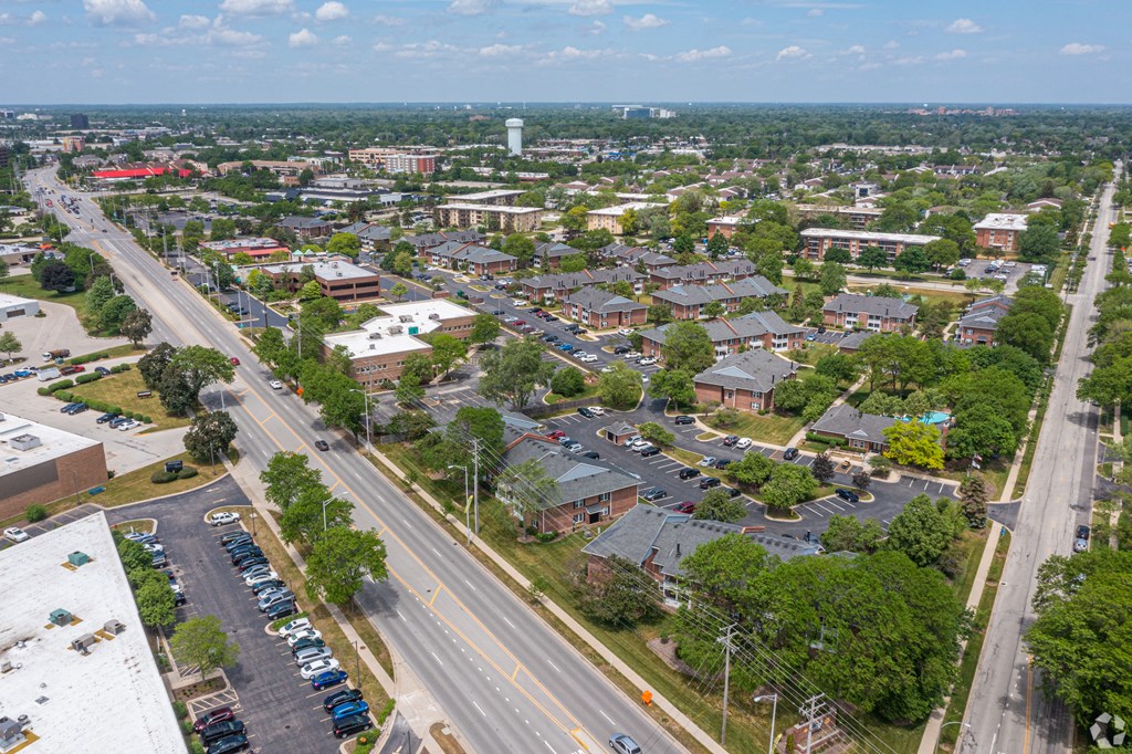 an aerial view of a city with cars parked on the street