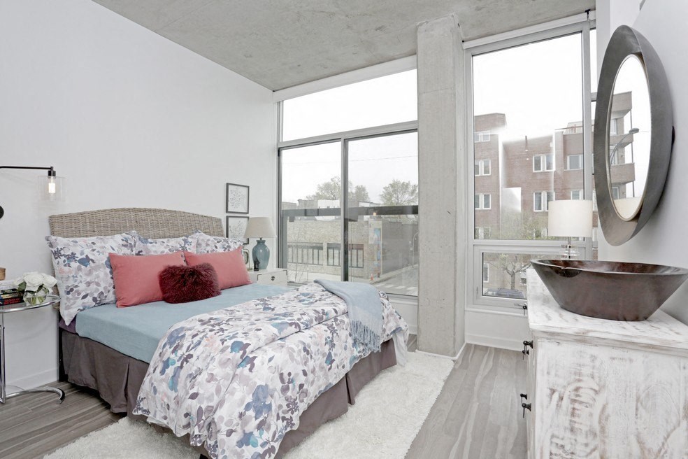 a bedroom with a bed and a large window