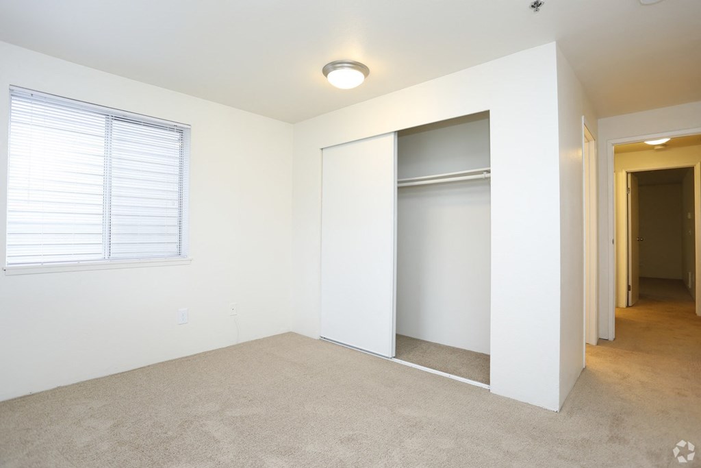 an empty room with a closet and a window