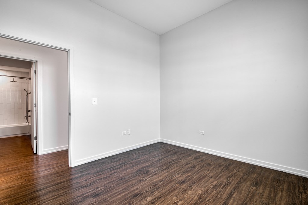 room with white walls and wood flooring and a doorway