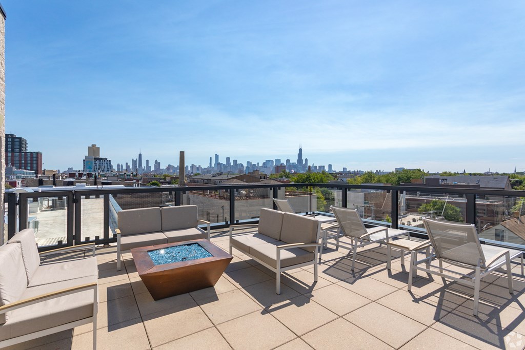 a terrace with chairs and a table and a view of the city
