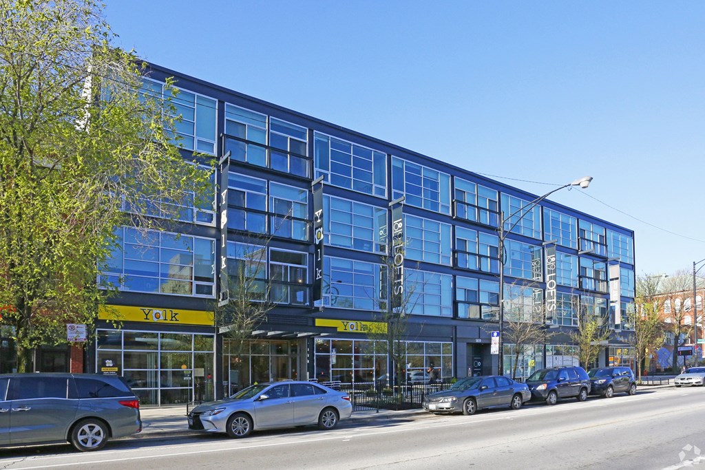 a large blue building on a city street with parked cars