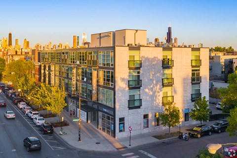 an aerial view of a building with a city skyline in the background