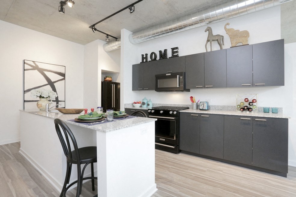 a kitchen with black cabinets and a white island with a counter top