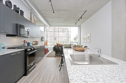 a kitchen with granite counter tops and a sink and a window