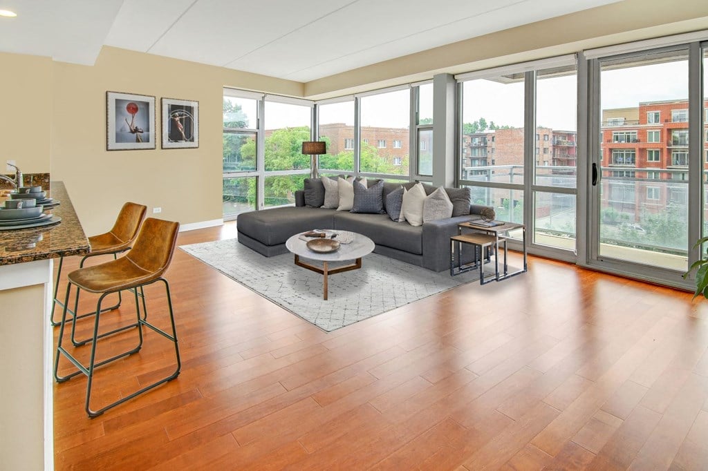 a living room with a couch and a table in front of glass doors