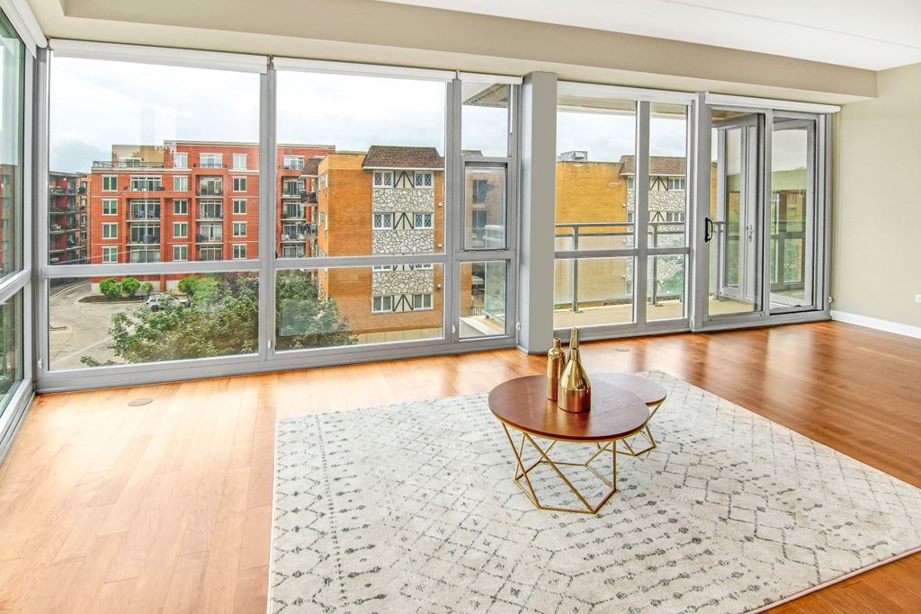 a living room with a large window and a rug and a table