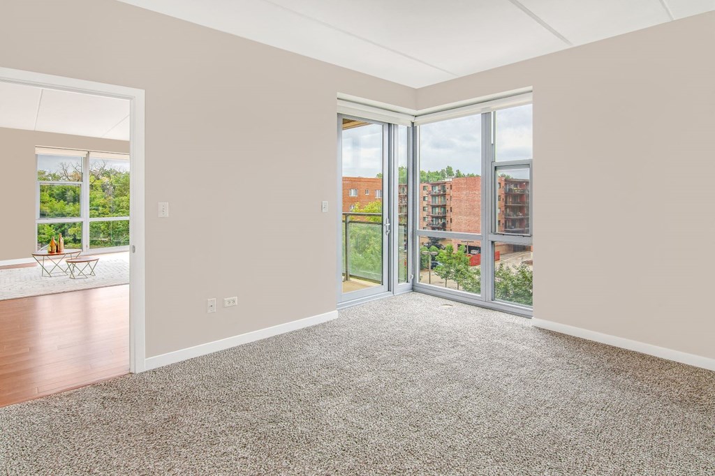 a living room with large windows and a carpet