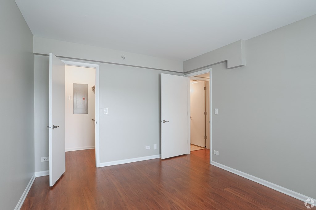 an empty living room with wood floors and white walls