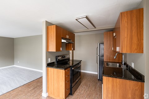 A kitchen with wooden cabinets and black appliances.