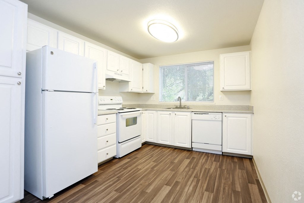 a white kitchen with white appliances and white cabinets