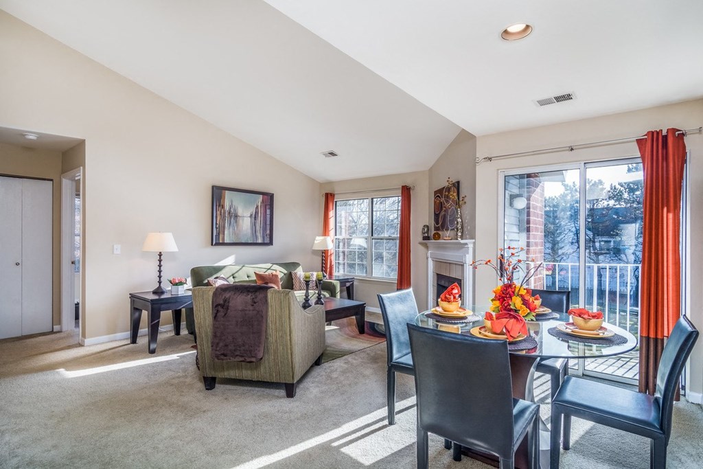 a living room and dining room with a table and chairs