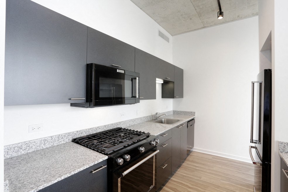 a kitchen with a stove and a microwave and a sink
