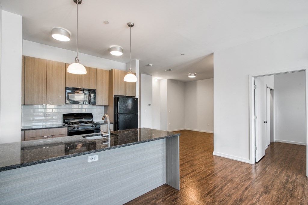 a living room with a kitchen with a counter top and