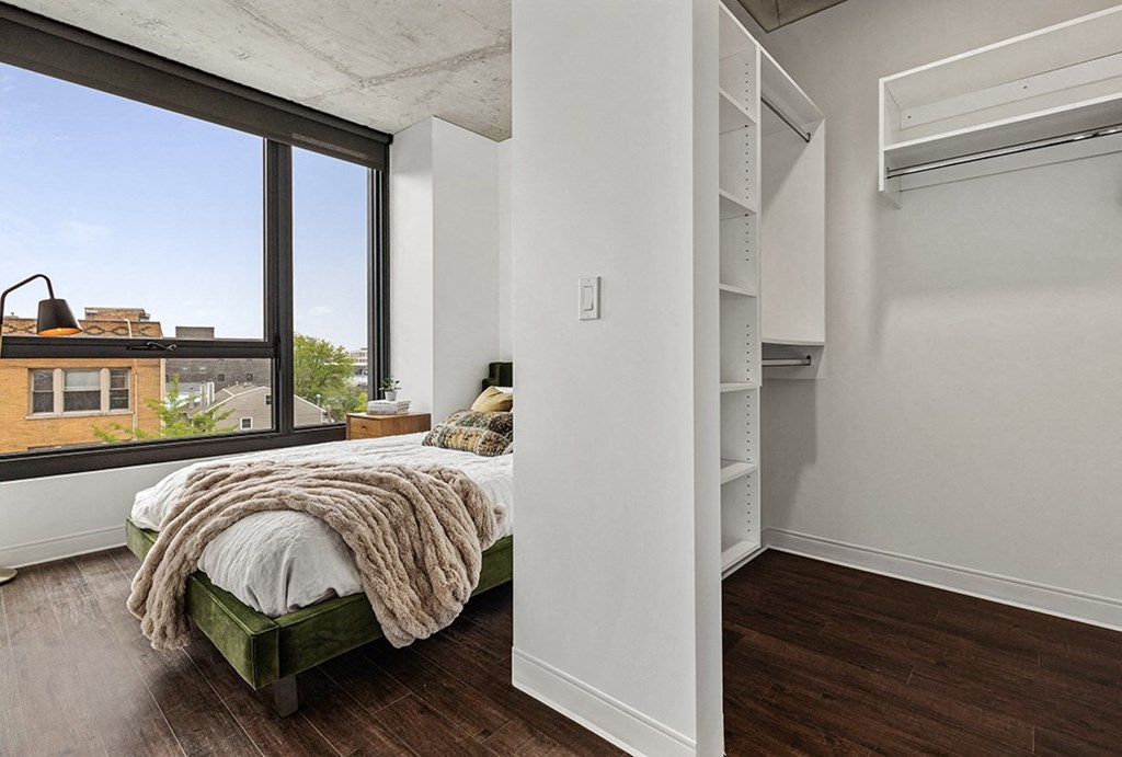 a bedroom with a bed and a large window