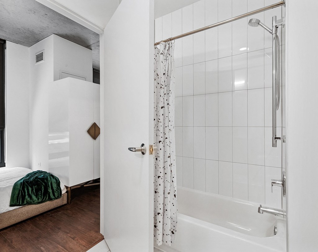 a white bathroom with a shower and a bed