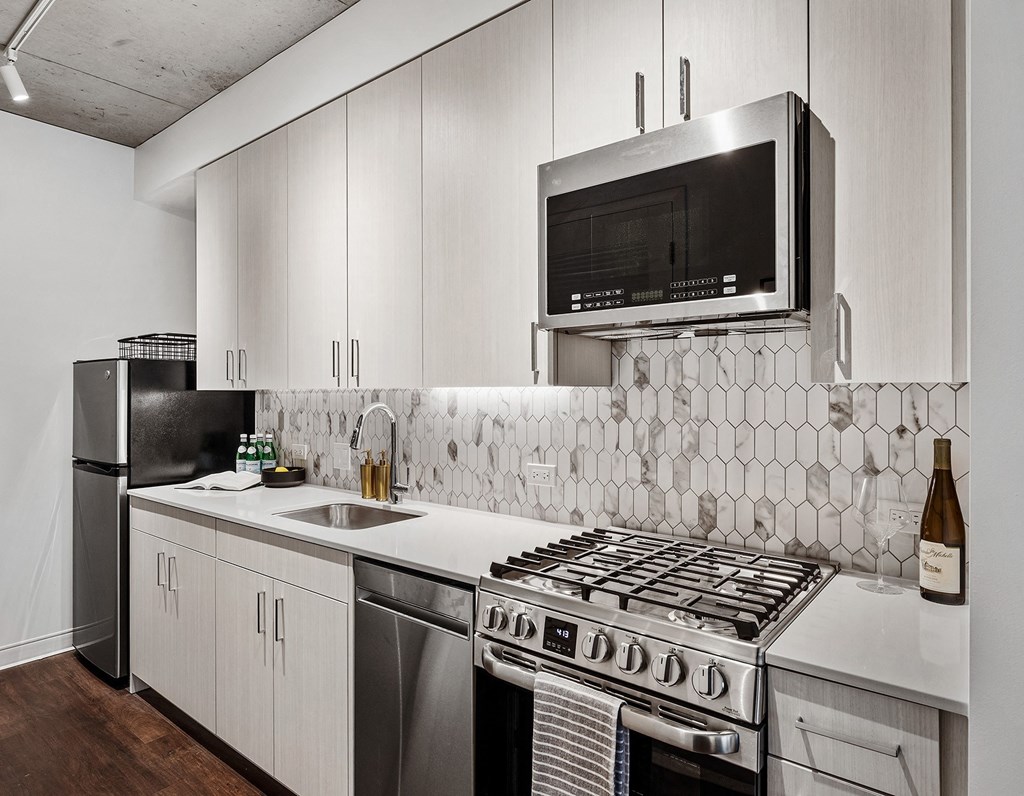 a kitchen with white cabinets and a stove and a microwave