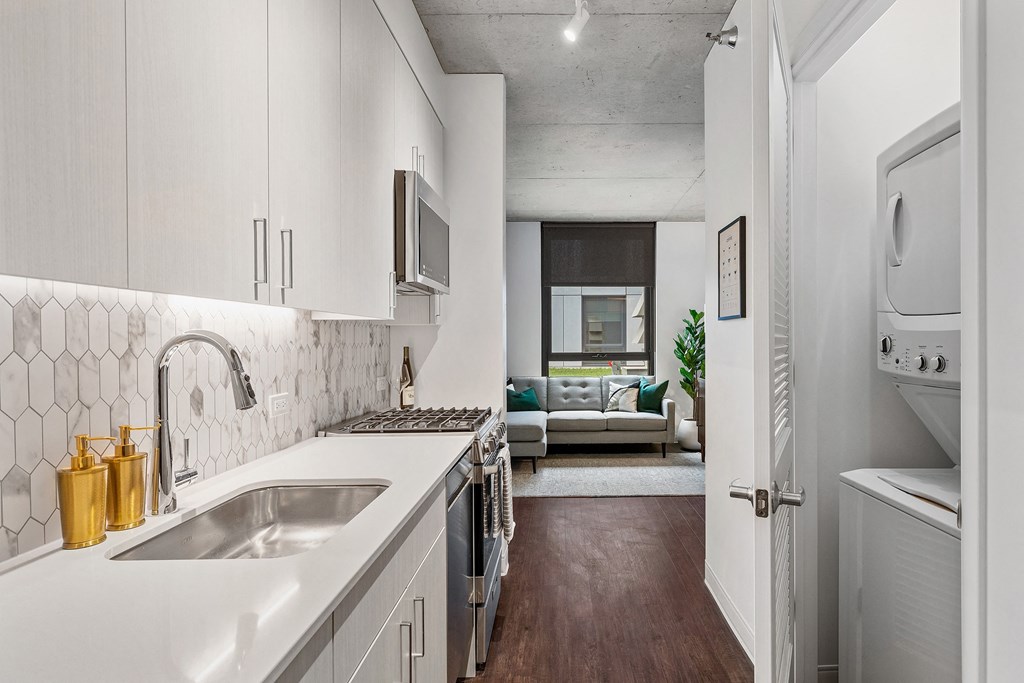 an open kitchen with white cabinets and a sink