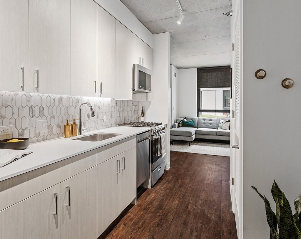 a kitchen with white cabinets and a sink and a microwave
