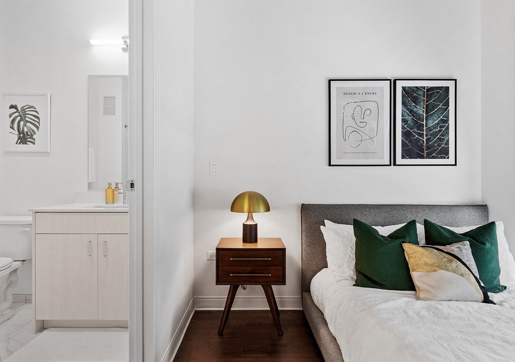 a bedroom with white walls and a bed with green pillows