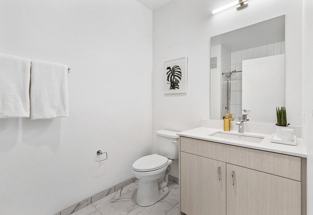 a bathroom with a sink toilet and a mirror