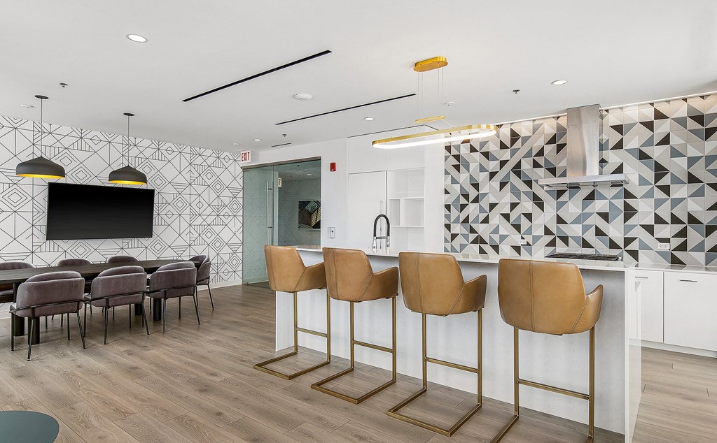 a communal area with a bar and chairs and a television