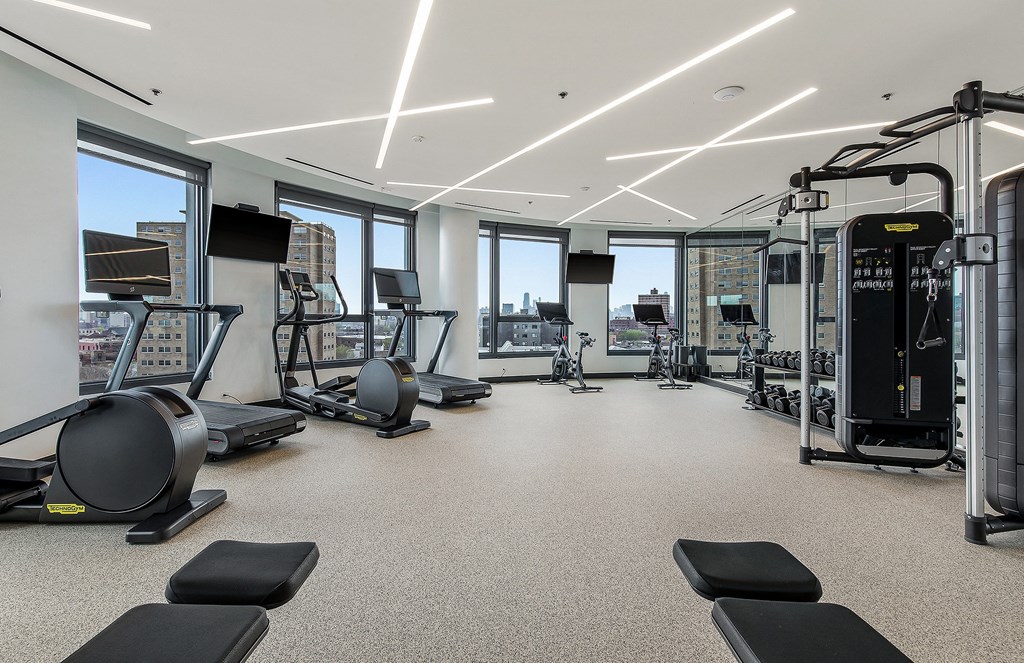 A spacious gym with treadmills, elliptical machines, and other exercise equipment.