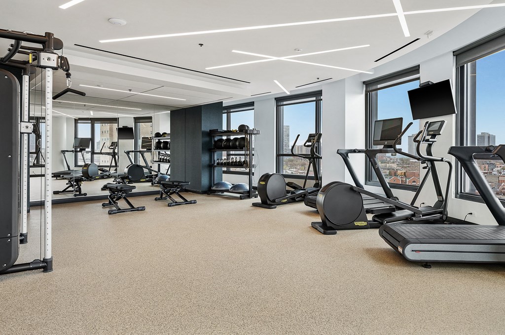 A spacious gym with a variety of equipment including treadmills, weights, and exercise machines.