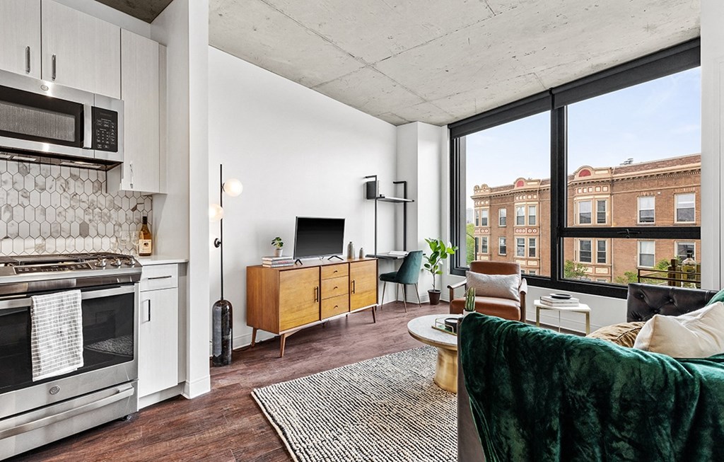 an open living room with a kitchen and a large window