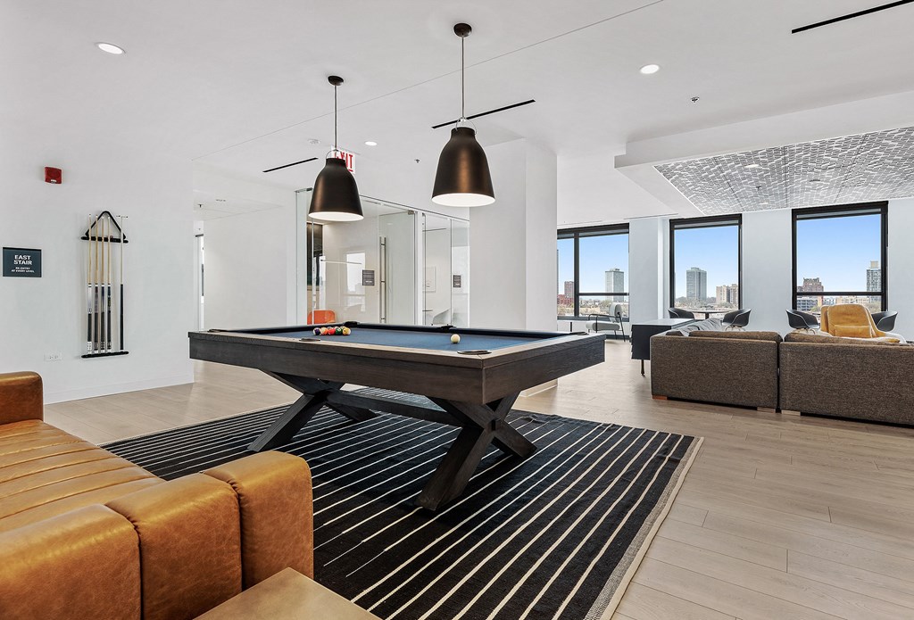 a living room with a pool table in the middle of it