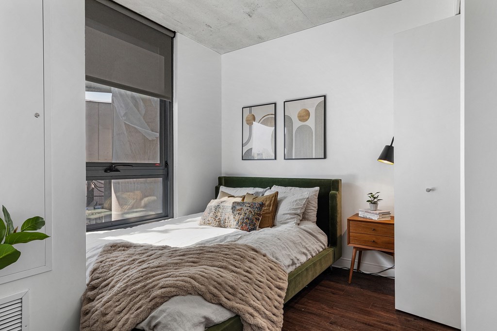 a bedroom with a bed and a large window