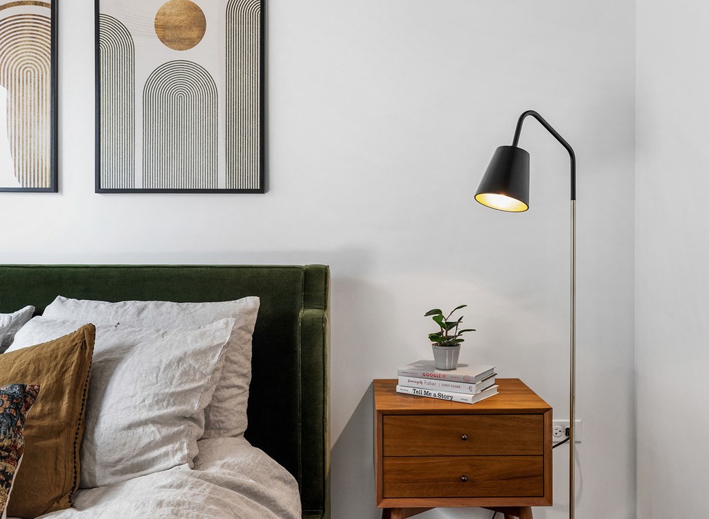 a bedroom with a bed and a night stand with a lamp