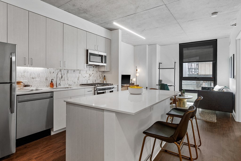 a kitchen with a large white counter top and a refrigerator