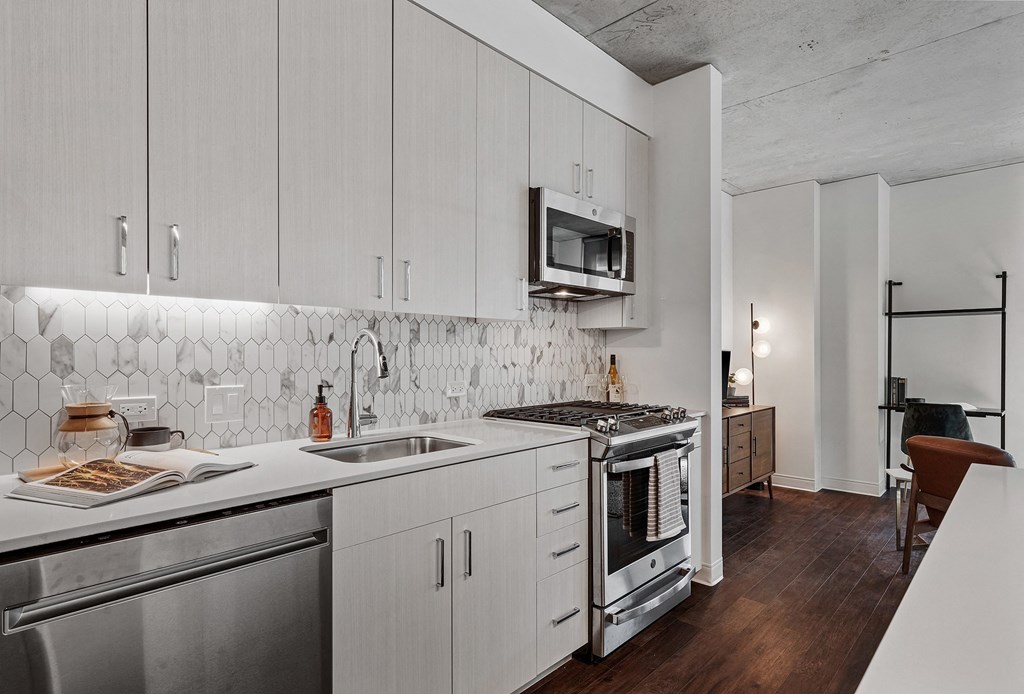 a kitchen with white cabinets and stainless steel appliances