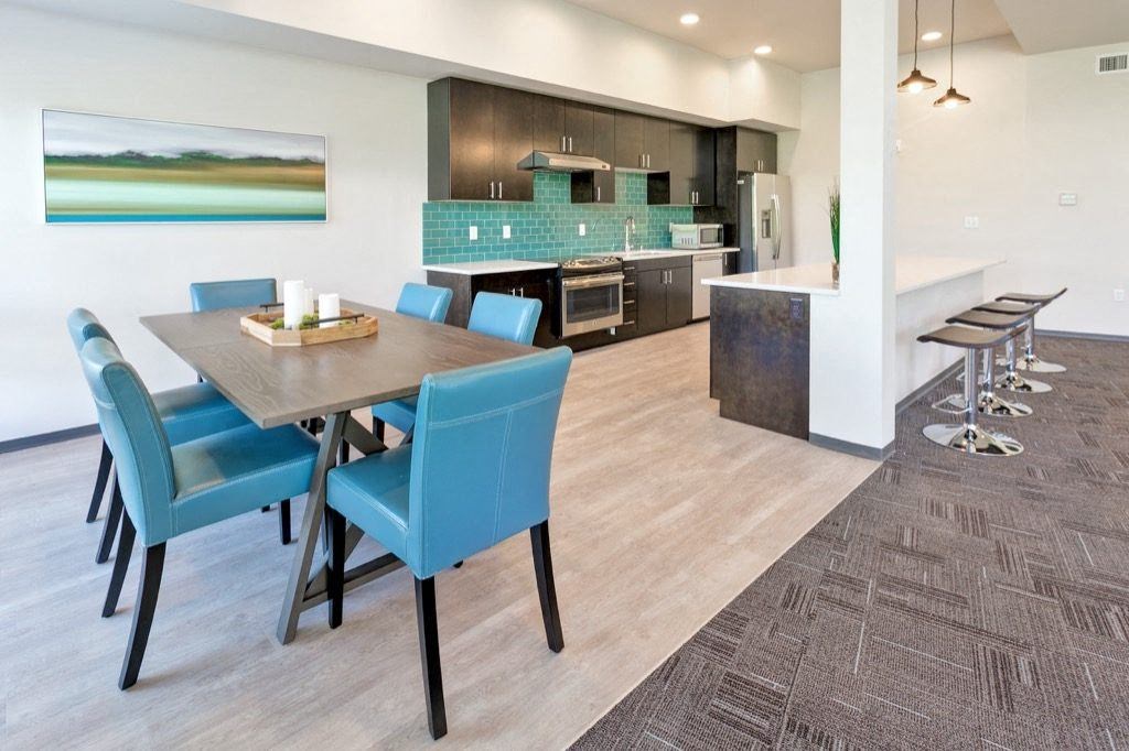 a dining room and kitchen with a table and chairs