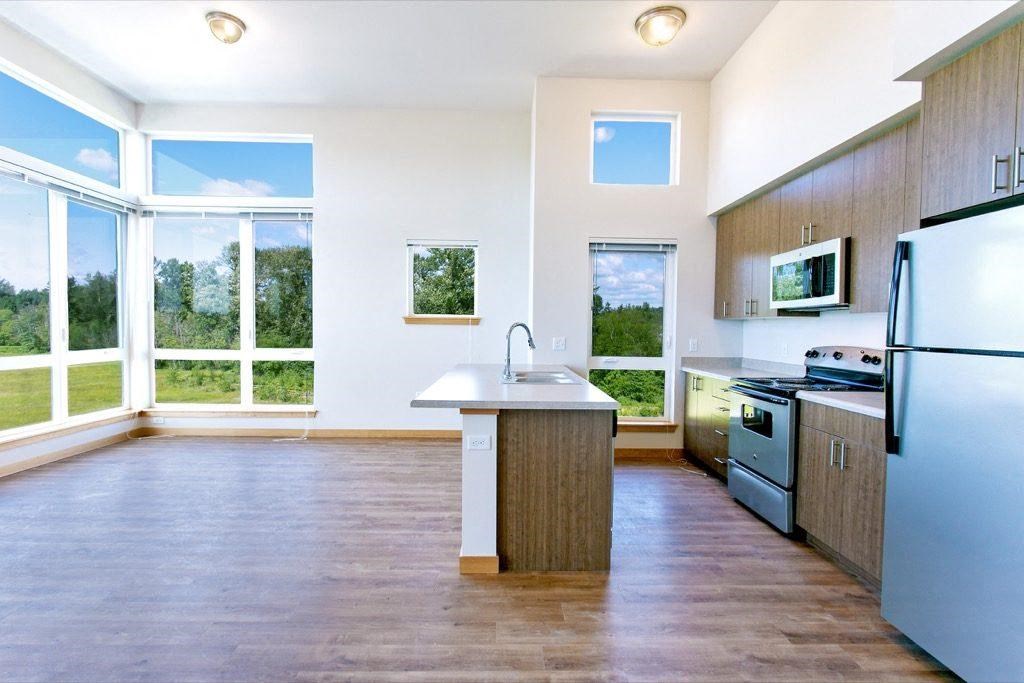 a kitchen with a large window and a sink and a refrigerator