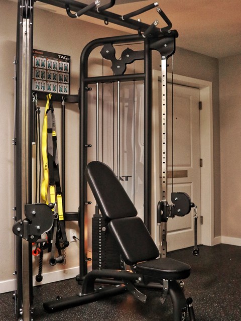 A black and yellow gym equipment set up in a room.
