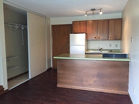 an empty kitchen with a counter and a refrigerator