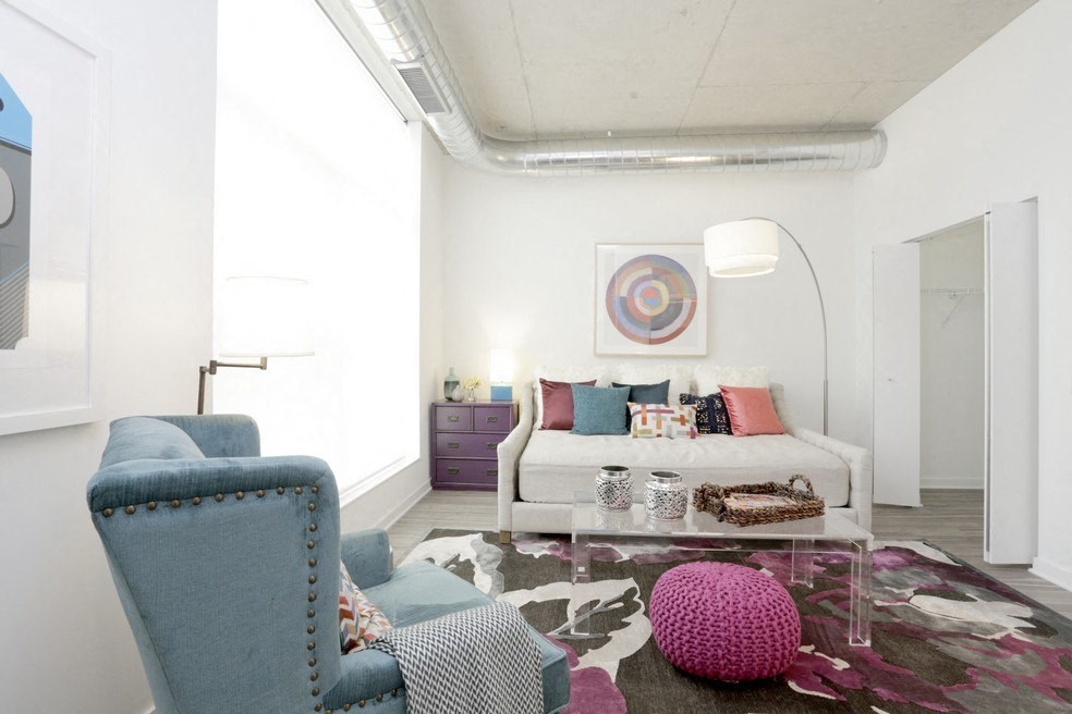 a living room with a white couch and a pink rug