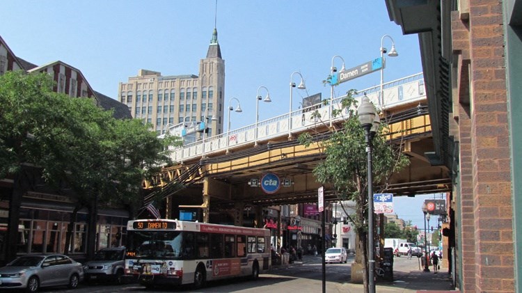 a bus driving under a bridge on a city street